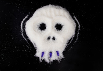 Sugar in the form of a skull on a black background. The concept of the harmful effects of...