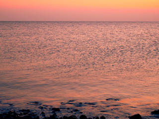 Fototapeta na wymiar Reflection on sea waves on dramatic sunset. Close up shot of dark red evening sinrise. Tripical ocean landscape