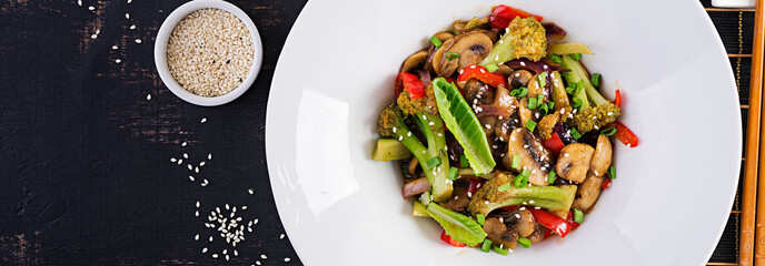 Stir fry vegetables with mushrooms, paprika, red onions and broccoli. Healthy food. Asian cuisine. Top view, banner