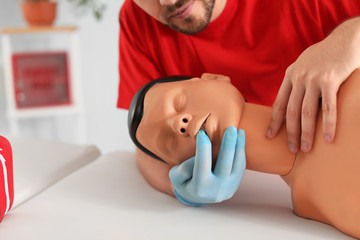 Instructor demonstrating CPR on mannequin at first aid training course