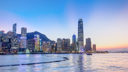 Hong Kong, China skyline panorama with skyscrapers day to night from across Victoria Harbor timelapse.