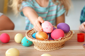 Little girl with painted Easter eggs at home