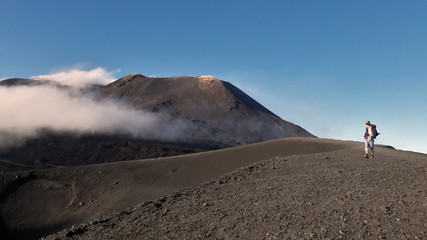 Man on smoking Etna volcano