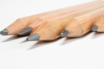 Macro detail of a 5 wooden pencils graphite isolated on white background with selective focus