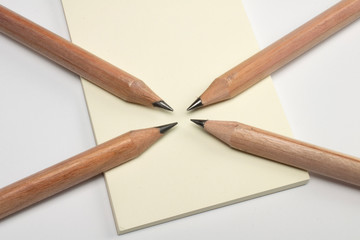 Opened diary with blank page and wooden pencils from above on neutral grey background