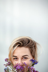 young woman with purple flowers on the light background. Closeup portrait - 324882098