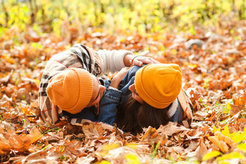 Lovely couple lies on the ground in autumn leaves. Sensual young couple walking in autumn park. Romantic autumn date.
