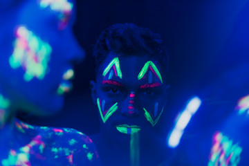 Close-up view of man with fluorescent make-up