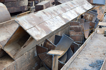 Fototapeta na wymiar A lot of building materials with metal spare parts, sticks, beams, pipes at an open-air construction site warehouse