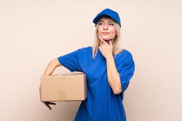 Young delivery woman over isolated background thinking an idea