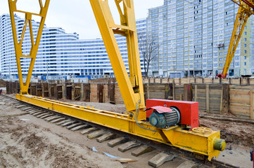 Large iron metal yellow supports on rails with wheels with an induction motor of a large...
