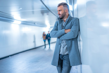 Street Style, cosmopolitan photo of a pensive young Caucasian brunette in the subway with a gray...