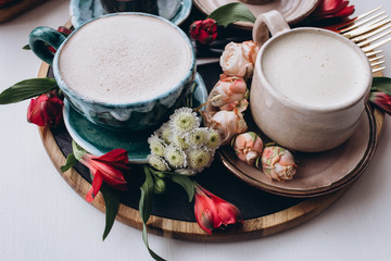 Close up blue coffee cup on white table in cafe with flowers