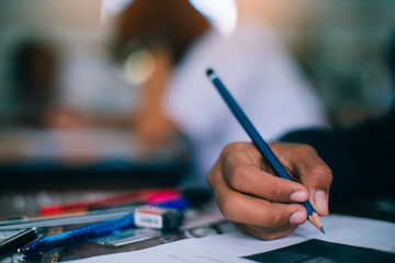 Students writing and reading exam answer sheets exercises in school with stress.