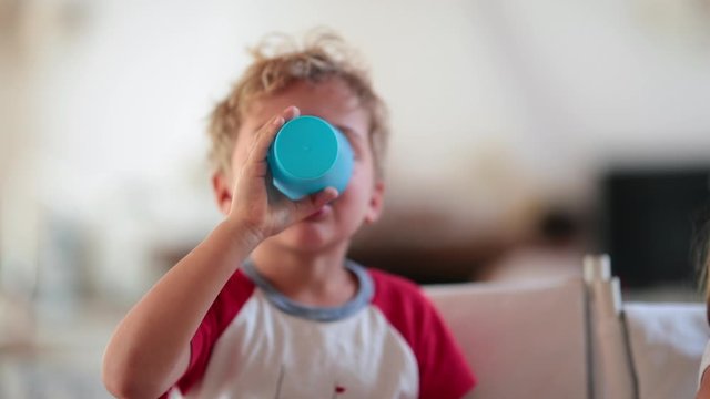 Child boy drinking beverage with cup and then burping and belching out loud