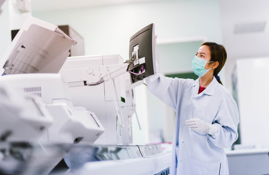 young female laboratory technician working with automation blood  analyzer in medical laboratory
