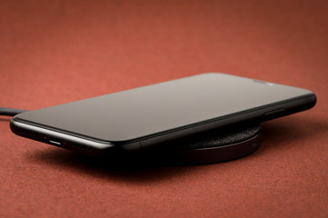 The smartphone is charged by a wireless charger  Concept of new technologies.