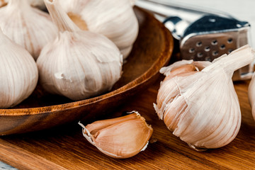 Garlic on a rustic table in a wooden bowl. Fresh peeled garlic.
