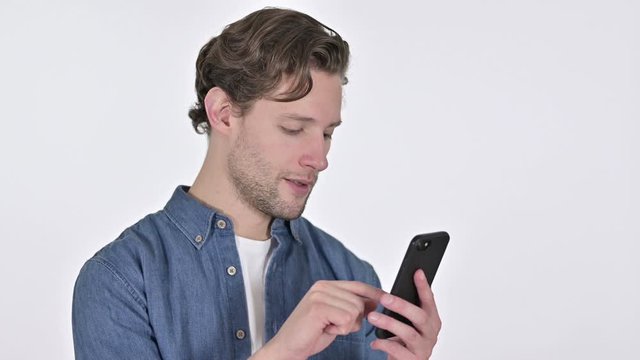 Portrait of Focused Young Man using Smartphone on White Background