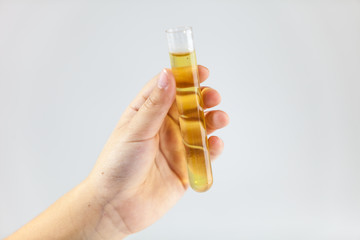 Hand holding test tube with liquid inside