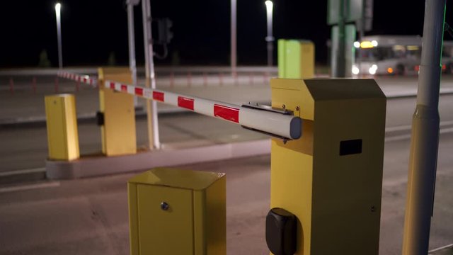 Automatic security system parking boom barrier car park system gate airport parking area access at night.
