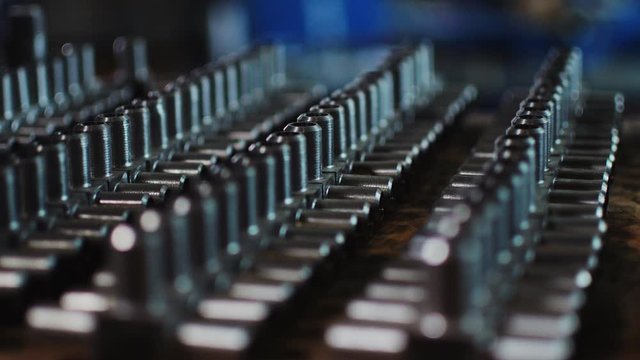 metal t-shaped pipe joints lie on wooden desk in workshop