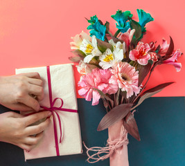 Partial view of woman with gift box and bouquet of flowers. Possible concepts of birthday, valentines day, anniversary, mothers day, wedding, love