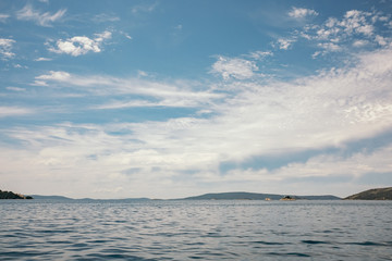 Wide view of a lake, clouds and mountains in the background