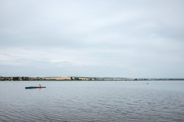 Wide view of a lake with canoeists.
