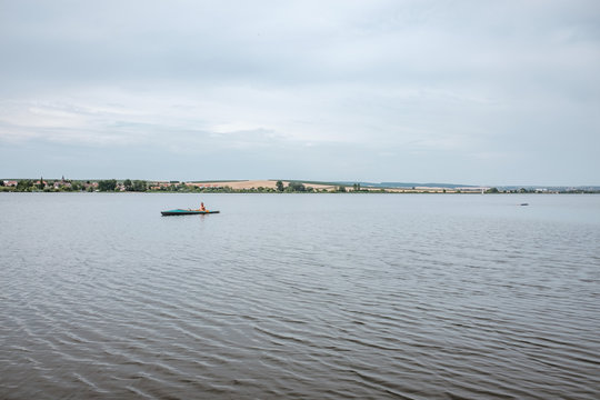 Wide view of a lake with canoeists.