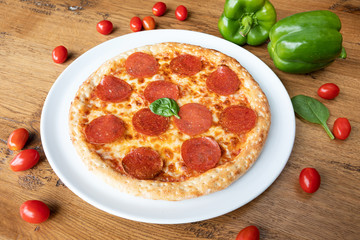 Tasty salami pizza on wooden table