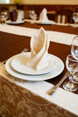 Table setting in a restaurant. Glass, plate, fork, knife