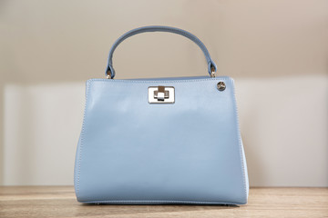 Light blue woman's bag on wooden shelf