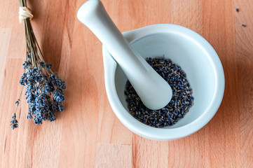 Top view of mortar and pestle with lavender flowers on wood table background. Natural cosmetic