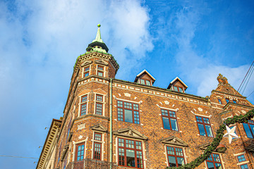Obraz premium Old brick house with a tower, against the blue sky