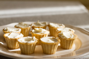 Tartlets with custard or cottage cheese. Empty tartlets or pie on a white table. Food lay flat. The view from the top. The concept of preparing food for the holiday table.