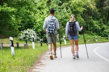 Two friends hiking in nature.They walking by the old country road.