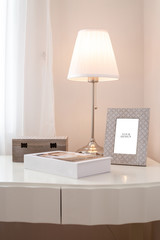 a book and mockup frame and lamp on the white table