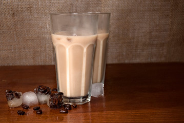 Coffee with cold brewed cold almond milk in a glass with  in the background with burlap. Iced...