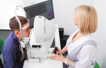 Teenager boy in ophthalmology office. Diagnosis of eye anterior segment and tomography of boy eyes