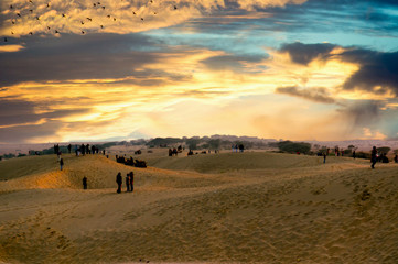 Fototapeta na wymiar People enjoying the sunset on sand dunes