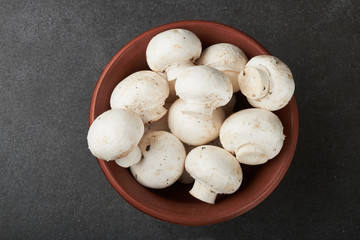 Fresh champignon mushrooms on wooden table, closeup. Space for text
