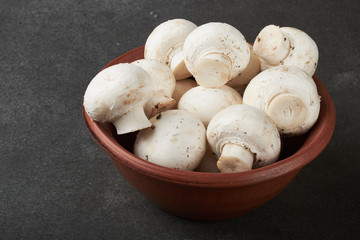 Fresh champignon mushrooms on wooden table, closeup. Space for text