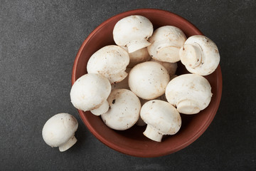 Fresh champignon mushrooms on wooden table, closeup. Space for text