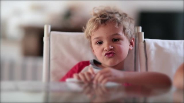 Happy adorable mischievous toddler boy teasing camera grimacing