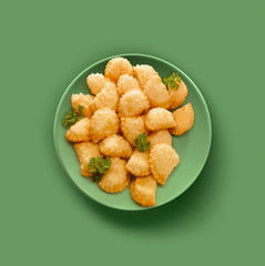 plato verde con empanadillas, sobre fondo verde. green plate with dumplings, on a green background.