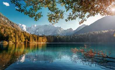 Scenic image of fairy-tale lake at sunny day. Majestic Rocky Mountains on background. Wild area. Fusine lake. Italy, Julian Alps. Best travel and hiking locations. Amazing nature landscape, postcard