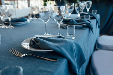 wedding table decor with blue tablecloth and glasses in restaurant