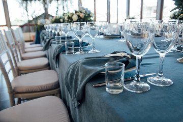 wedding table decor with blue tablecloth and glasses in restaurant