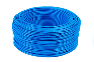 Round roll of blue electrical single core cable lying on workshop table isolated white background